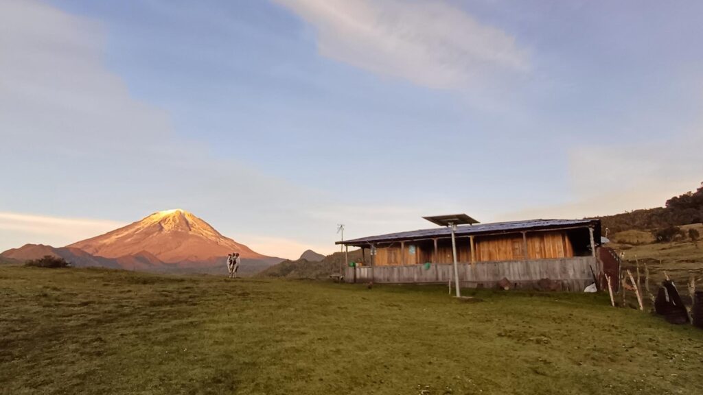 Mountain lodge Casa del Oso with Nevado del Tolima in the background at sunrise in Colombia.