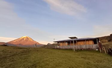 Mountain lodge Casa del Oso with Nevado del Tolima in the background at sunrise in Colombia.