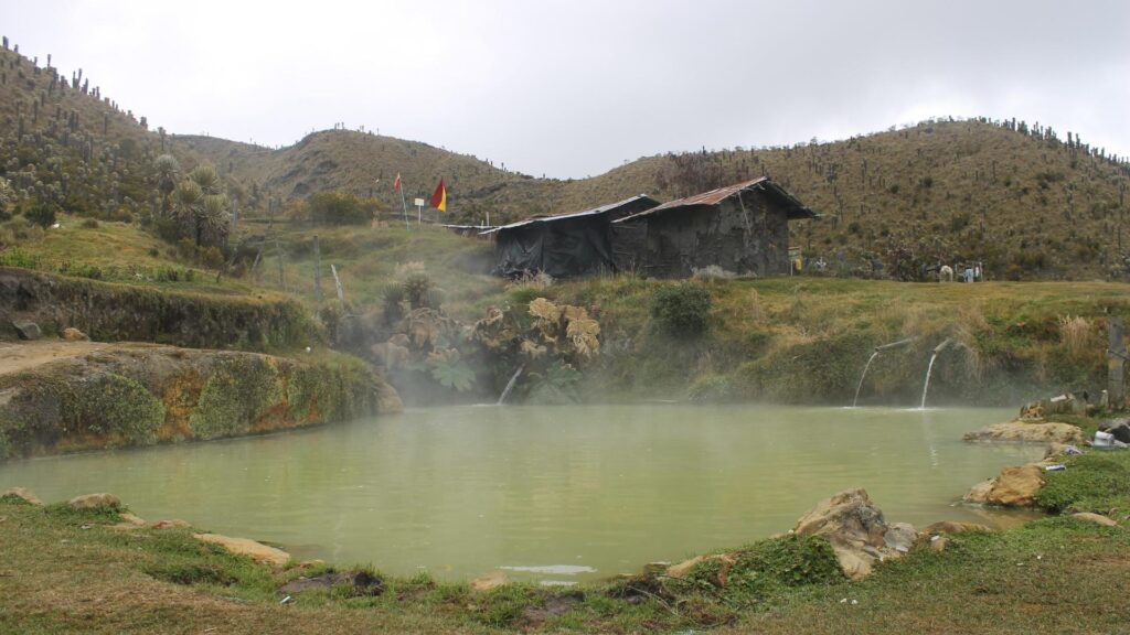 Natural hot springs Termales del Cañón in the Colombian Andes near Nevado del Tolima, with rustic shelter and steaming water.