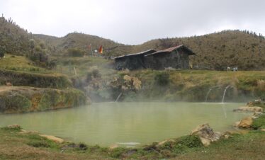 Natural hot springs Termales del Cañón in the Colombian Andes near Nevado del Tolima, with rustic shelter and steaming water.