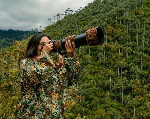 Wildlife photographer birdwatching in Colombia’s cloud forest with wax palms in Toche, near the Cocora Valley, searching for birds and Andean wildlife