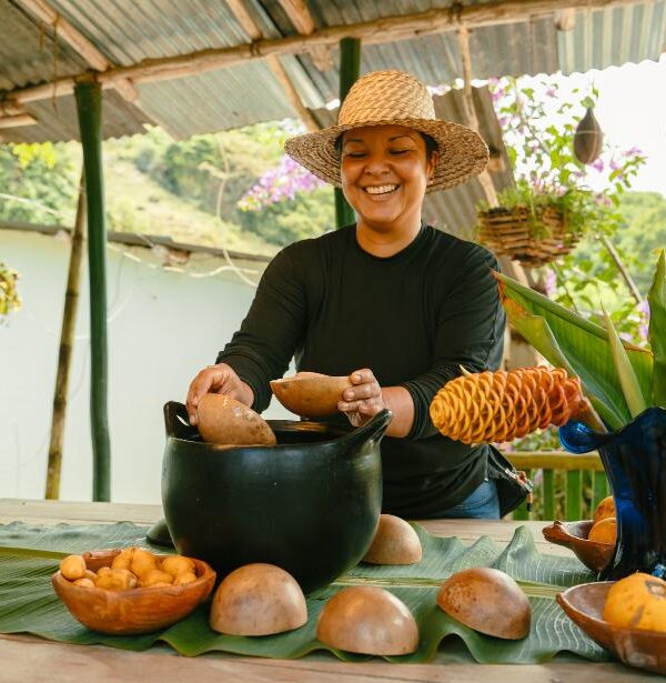 Local host preparing traditional Colombian chicha in a clay pot from la chamba with natural totuma bowls during a cultural immersion experience in rural Colombia