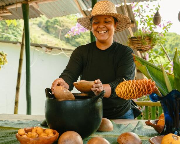 Local host preparing traditional Colombian chicha in a clay pot from la chamba with natural totuma bowls during a cultural immersion experience in rural Colombia