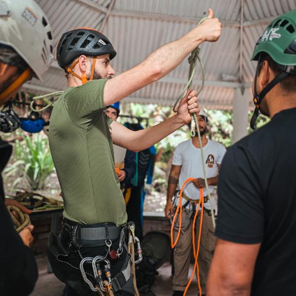 Outdoor instructor teaching rope systems and technical safety skills during a canyoning, mountaineering and rescue training course in Colombia