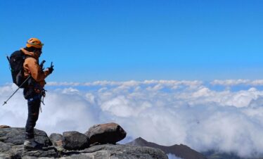 Mountaineer above clouds on Nevado del Tolima summit route in Colombia Andes