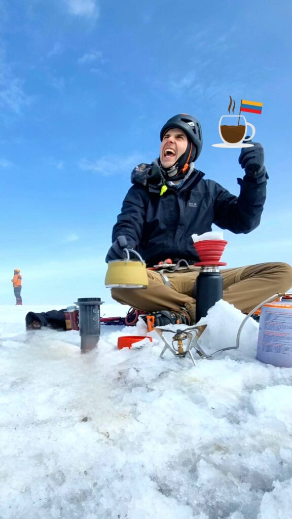 Mountaineer brewing Colombian coffee on the glacier of Nevado Santa Isabel during a high-altitude expedition in the Colombian Andes