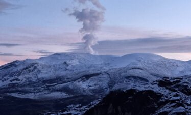 Nevado del Ruiz volcano emitting a steam plume above snow-covered slopes in Los Nevados National Natural Park, Colombia.