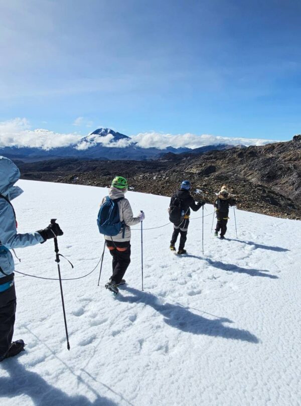 Travelers hiking roped together across the Nevado Santa Isabel glacier during a guided glacier trek in Los Nevados National Natural Park, Colombia
