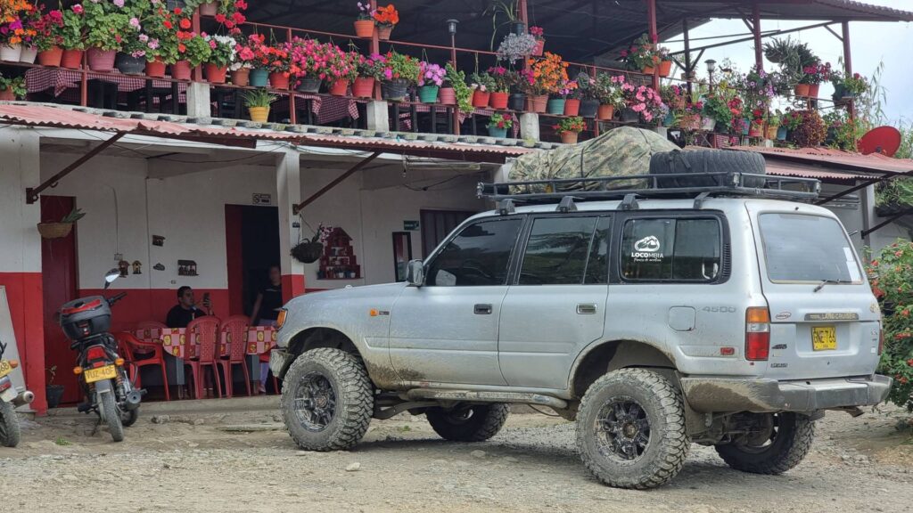 Toyota Land Cruiser 4x4 expedition vehicle parked at a rural mountain house during an adventure travel journey in Colombia.