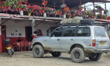 Toyota Land Cruiser 4x4 expedition vehicle parked at a rural mountain house during an adventure travel journey in Colombia.